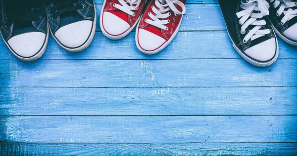 Tre par bär sneakers på en blå trä yta, topp vi — Stockfoto