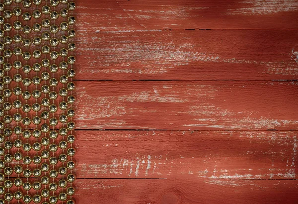 Fondo de madera naranja con una guirnalda de bolas doradas —  Fotos de Stock