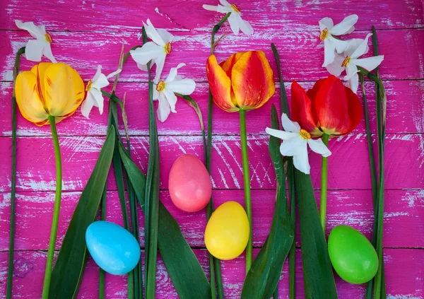 Chocolate colored eggs among fresh flowers tulips and daffodils — Stock Photo, Image