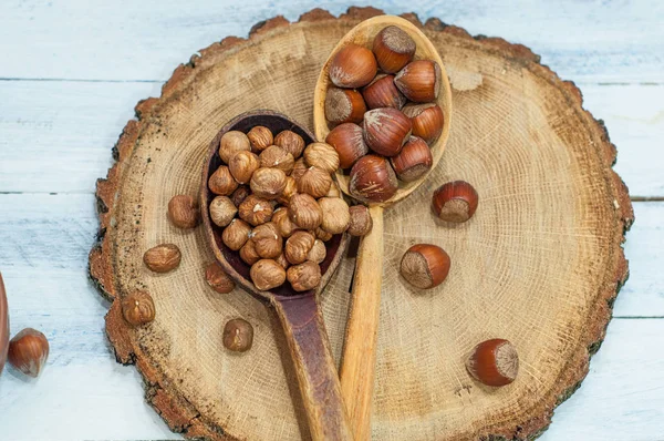 Noisette dans une cuillère en bois, dans la coquille et pour décortiquer — Photo