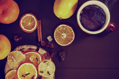 Çay bir kupa ile kurutulmuş narenciye meyve ve baharat siyah woode üzerinde