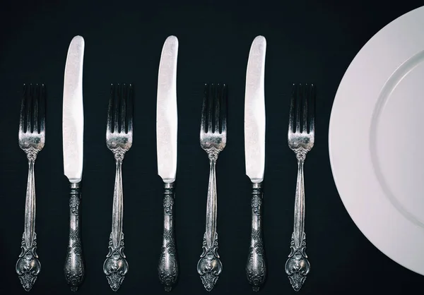 Half empty white plates, vintage knife and fork on  table — Stock Photo, Image