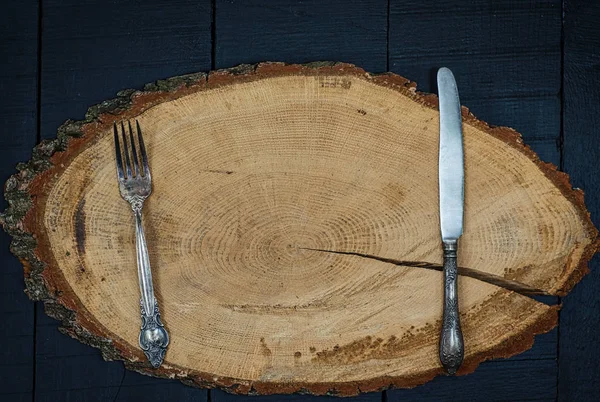 Tenedor y cuchillo en un marco de madera, el espacio vacío en el centro — Foto de Stock