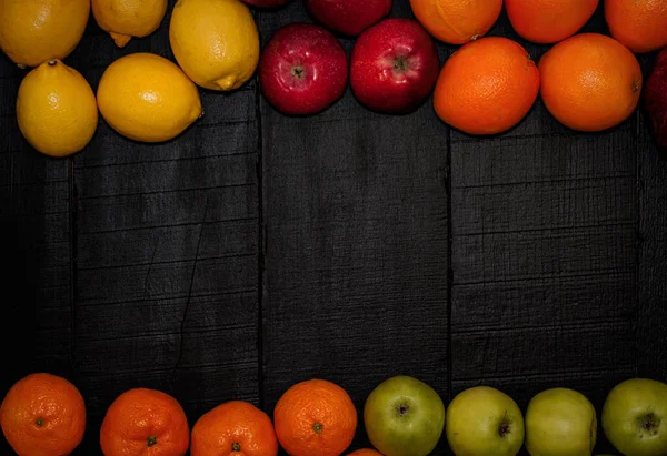 Mogna frukter läggs ut på omkretsen på en svart trä tillbaka — Stockfoto