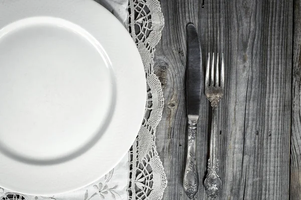 Piring kosong putih pada taplak meja dengan renda, dekat pisau dan fo — Stok Foto