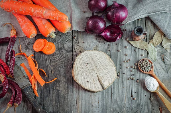 Свежая морковь и лук на сером деревянном столе — стоковое фото