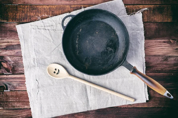 Panela de ferro fundido com uma espátula em um guardanapo têxtil cinza — Fotografia de Stock