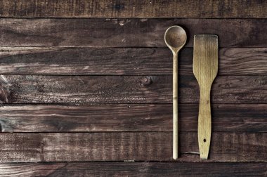 Ahşap mutfak spatula ve kahverengi bir yüzey üzerinde bir kaşık