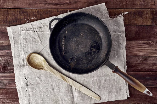 Panela de fritura preta vazia em uma superfície de madeira marrom — Fotografia de Stock