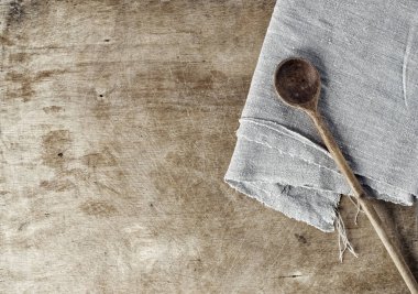Tahta kaşık ve gri bir tableclot ile kahverengi ahşap arka plan