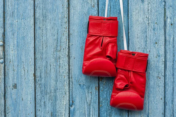 Pair of red boxing gloves hanging on a nail — Stock Photo, Image