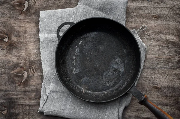 Frigideira de ferro fundido preto vazia em um guardanapo têxtil — Fotografia de Stock