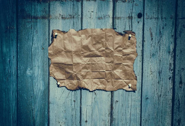 Papel kraft enrugado marrom pendurado em uma superfície de madeira azul — Fotografia de Stock
