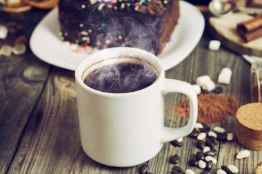 Gri bir ahşap yüzeyde sıcak siyah kahve ile beyaz fincan