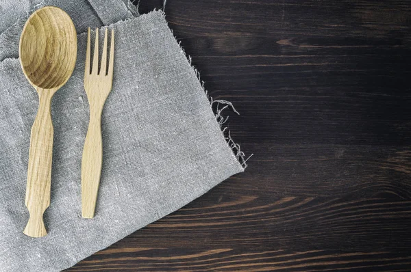 Cuchara de madera y tenedor en servilleta gris — Foto de Stock