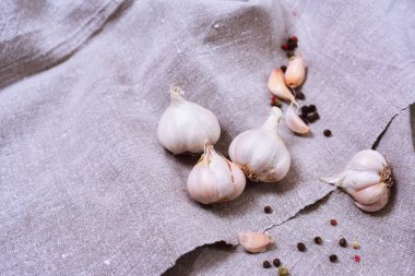 Beyaz çiğ sarımsak başları üzerinde gri bir bez