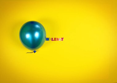 Sarı bir yüzey üzerinde mavi balon ve yazıt tatil