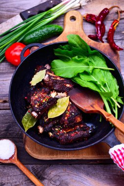 Baharat Domuz kaburga üzerinde siyah bir dökme demir tavada pişmiş