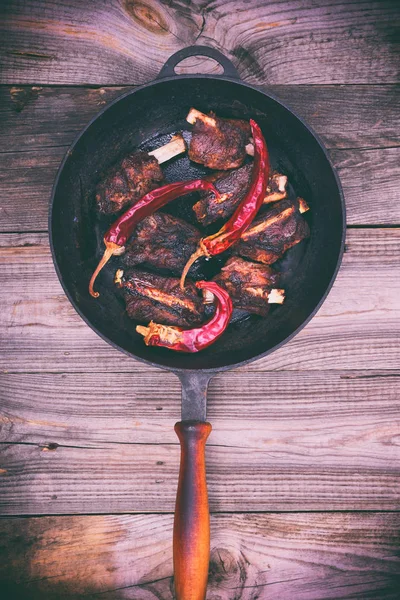 Costillas de cerdo y pimiento picante en una sartén negra con mango — Foto de Stock