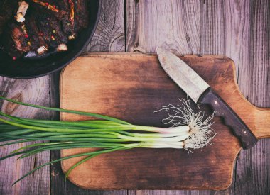 Bir mutfak kesme tahtası üzerinde yeşil soğan