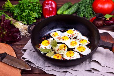Bir dökme demir tavada kızarmış bıldırcın yumurtası