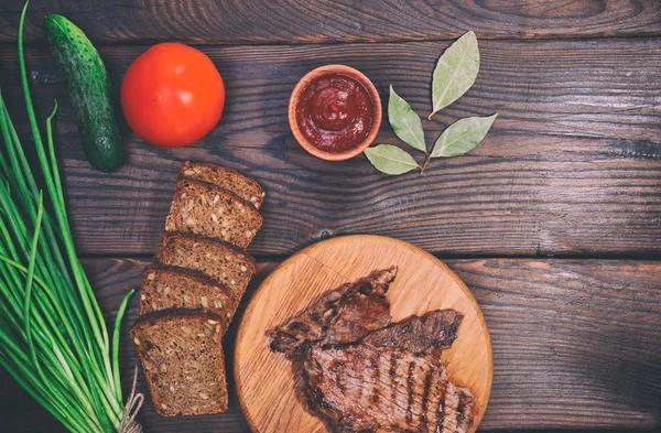 Pieces of grilled veal, brown wooden background — Stock Photo, Image