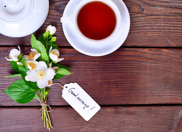 Šálek čaje a kytici bílých květu jasmínu — Stock fotografie