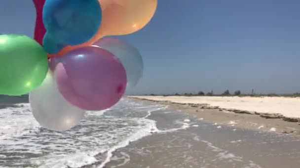 Různobarevné balónky na pozadí moře — Stock video