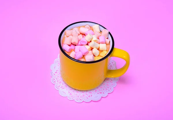 Caneca amarela com cacau e pedaços de marshmallow colorido — Fotografia de Stock