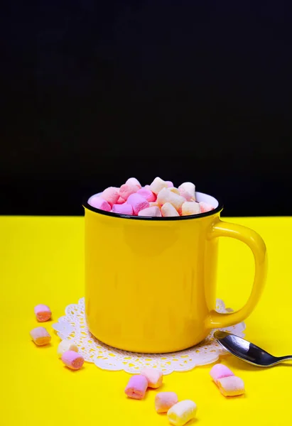 Cacau com marshmallow em uma caneca amarela, ao lado de uma colher de ferro — Fotografia de Stock