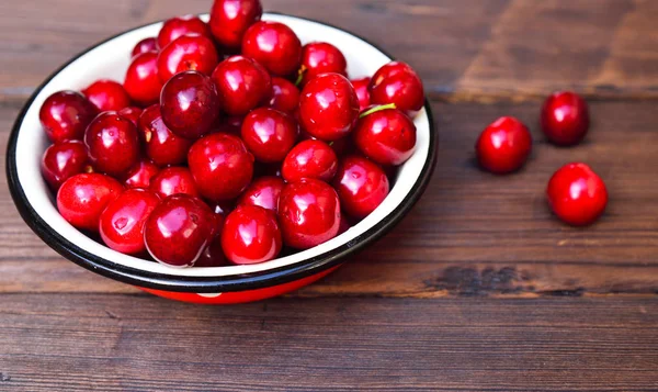 Ripe red cherry in an iron bowl