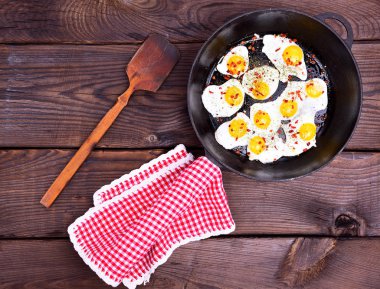Siyah bir tavada kızarmış bıldırcın yumurtası 