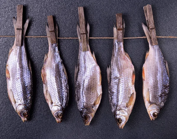 Kurutulmuş balık bir ip üzerinde asılı 