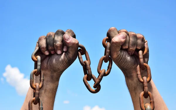 Dos manos masculinas sosteniendo una cadena metálica oxidada — Foto de Stock