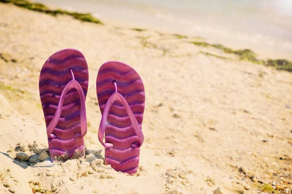 Pantofole da spiaggia viola sulla spiaggia — Foto Stock