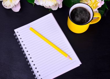 Kağıt defter ile sarı bir ahşap kalem 