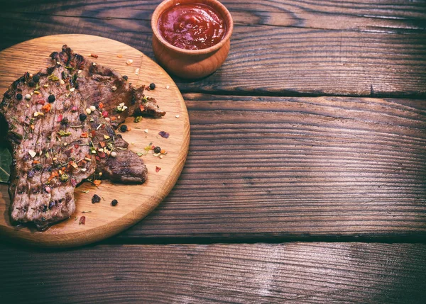 Trozo de ternera frita con especias en una tabla de cortar — Foto de Stock