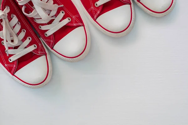 在白色的木制表面红色运动鞋青年 twopair — 图库照片
