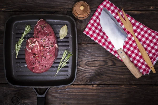 Filete de carne cruda con especias en una sartén negra — Foto de Stock