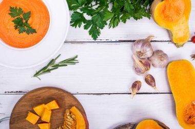 Beyaz bir tabak ve malzemeler balkabağı çorbası 