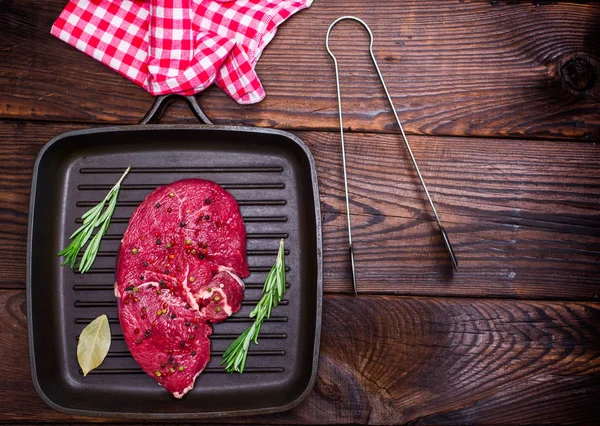 Filete de carne cruda en una sartén de cuarteto negro — Foto de Stock