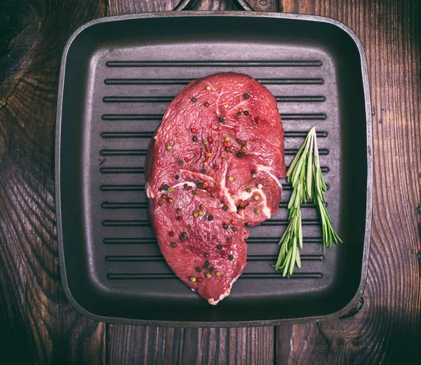 Carne cruda en una sartén negra — Foto de Stock