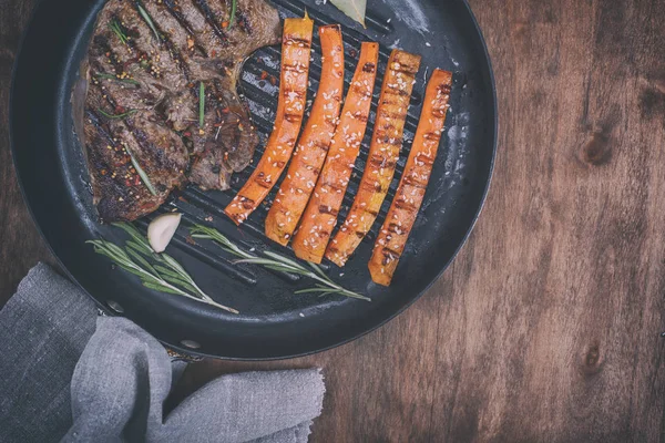 Trozo de ternera en una sartén redonda con zanahorias fritas — Foto de Stock