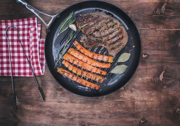Gebakken rundvlees stack en gebakken wortelen op een ronde braadpan — Stockfoto