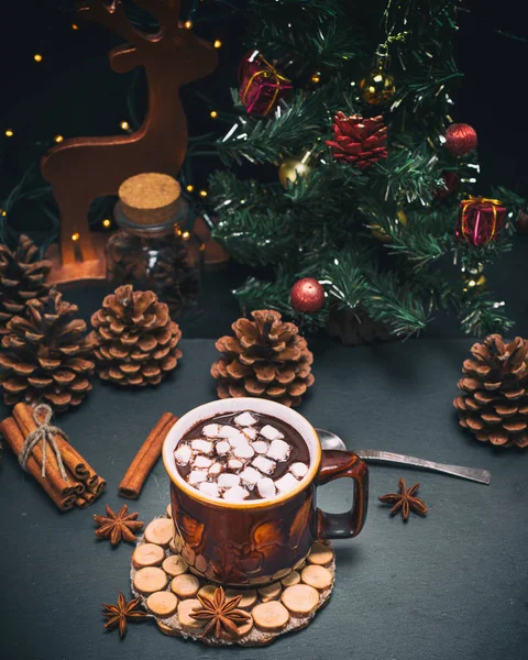 Chocolate caliente con malvaviscos en una taza marrón sobre un fondo negro — Foto de Stock