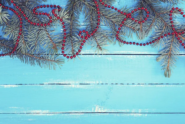 Ramas de abeto verde con una guirnalda roja de Navidad — Foto de Stock