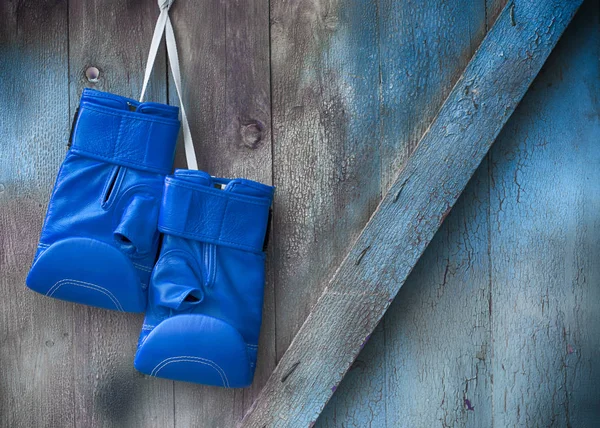 Blue box rukavice pověsit na hřebík na dřevěné omšelé zdi — Stock fotografie