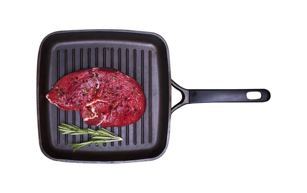 Rohes Rindfleisch mit Gewürzen auf einer schwarzen quadratischen Pfanne — Stockfoto