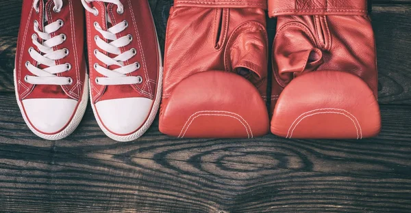Ζευγάρι κόκκινα αθλητικά παπούτσια και τα γάντια του μποξ κόκκινο δέρμα — Φωτογραφία Αρχείου