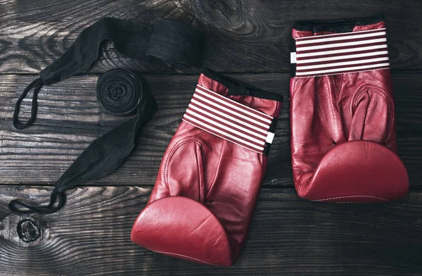 Gants de boxe en cuir rouge et bandage élastique noir — Photo